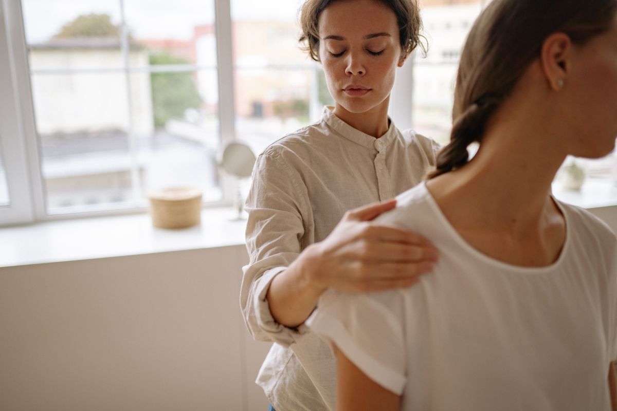 Physiotherapist assessing a patient's shoulder in a bright, modern clinic